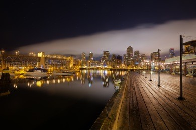 night reflection of burrard bridge by the pier planks in granville island, vancouver