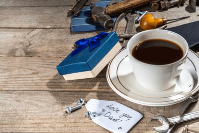 father day greeting card background. fathers day concept with gift box, tools and ties, coffee cup, gift tag  love you dad, on rustic wooden background top view copy space