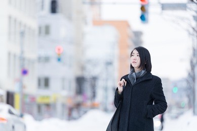 young asian woman walking on a winter city.