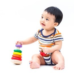 cute asian baby playing toy isolated on white