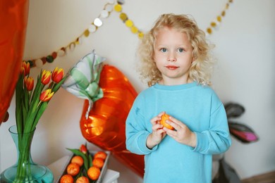  girl hold easter eggs against the backdrop of easter decorations