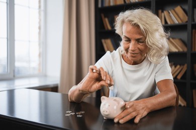 saving money investment for future. senior adult mature woman putting money coin in piggy bank. old grandmother counting saving money planning retirement budget. investment banking concept