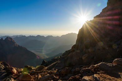 egypt, sinai, mount moses. view from road on which pilgrims climb the mountain of moses and dawn - morning sun with rays on the sky.