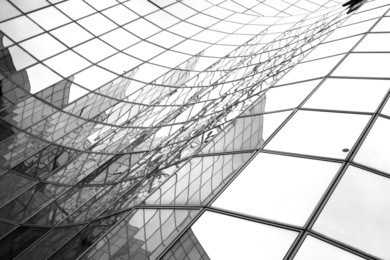 glass surface of skyscrapers view in district of business centers with reflection on it, black and white 