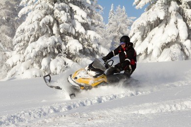 athlete on a snowmobile moving in the winter forest in the mountains of the southern urals.