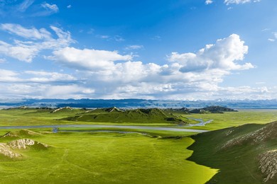curved river and green grassland with mountain natural landscape in xinjiang