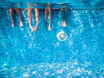 children's and adults legs underwater in the swimming pool