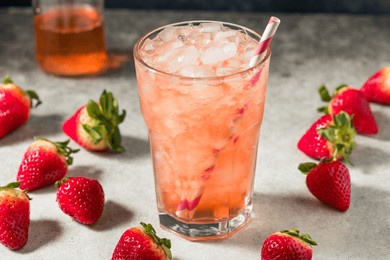 cold refreshing strawberry soda with ice and a straw