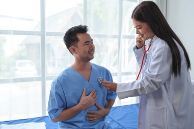a female doctor uses a cardiac stethoscope to treat patients to analyze and listen to whether their heart rhythm is abnormal or normal. to make a diagnosis from the patient for further treatment.