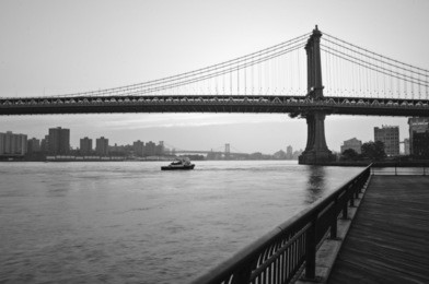 sunrise over the manhattan bridge from the brooklyn bridge park in black and white.