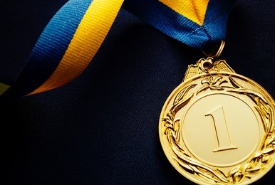gold medal in the foreground on yellow blue ribbon