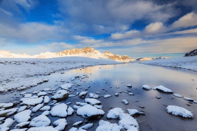 winter scenery with frozen alpine lake, stelvio pass, valtellina, lombardy, italy, europe