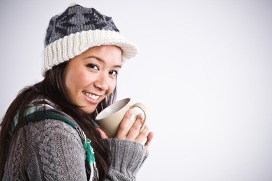a shot of a happy beautiful asian woman drinking coffee