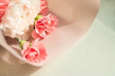 pink bouquet of carnation flowers on wooden background - mothers day concept