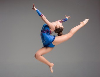 teenager doing gymnastics dance  in  jumping on a gray background