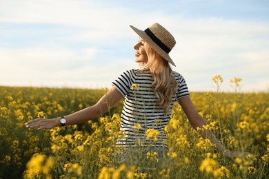 happy young woman with straw hat in field on spring day
