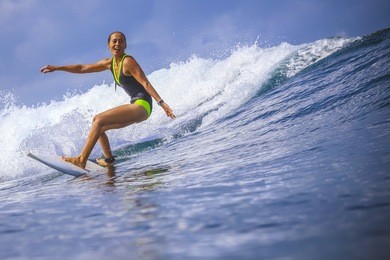 surfer girl on amazing blue wave, bali island.