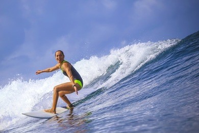 surfer girl on amazing blue wave, bali island.