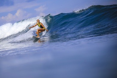 surfer girl on amazing blue wave, bali island.