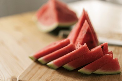 triangular pieces of watermelon on a wooden cutting board.