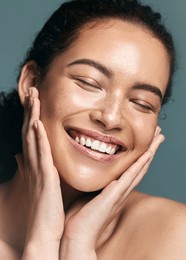 eyes closed, beauty and woman with skincare, shine and dermatology on grey studio background. acne treatment, cosmetics and glow with wellness, person and hands on face for grooming and routine
