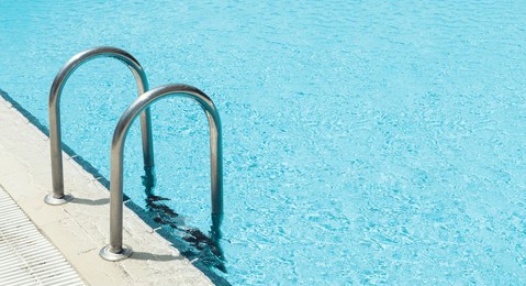 swimming pool and railings with clear turquoise water in the outdoor background