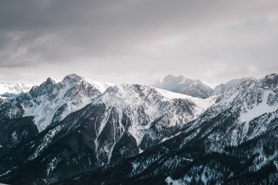 snow-covered mountains, their peaks blanketed in white, create a stunning and serene winter landscape, highlighting the pristine beauty of the natural world