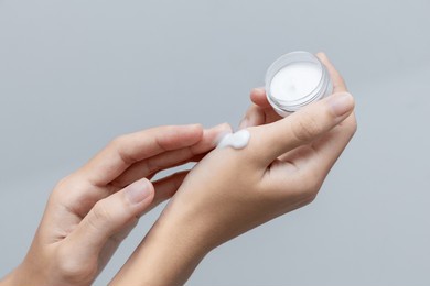 a woman applies a cosmetic cream on her hands. hand skin care concept.