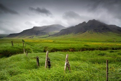 beautiful landscape of icelandic field with fence and mountain
