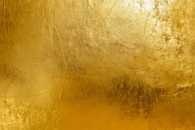 elegant gold foil texture with distressed finish for luxury design. abstract grunge metallic surface with scratches and smudges. versatile golden backdrop for creative projects in fashion