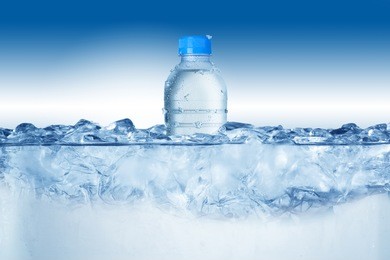 cold water bottle in ice bucket with ice cubes