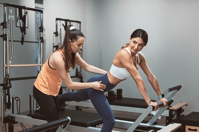 young women exercising in a gym on pilates machines.