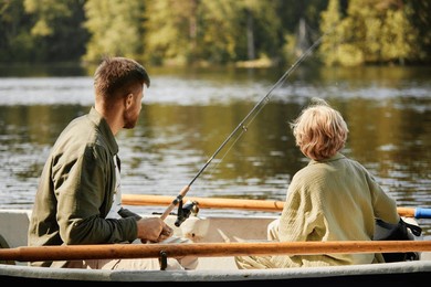 two individuals enjoying serene fishing experience in a boat on lake surrounded by lush greenery and calm waters providing peaceful scene for outdoor recreation