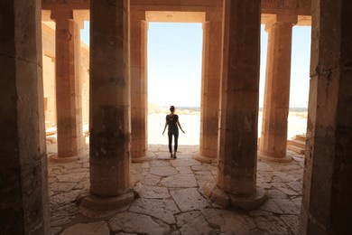 woman standing amongst columns in egypt
