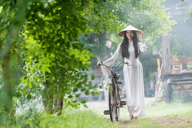 young vietnamese woman on a bus in the countryside. ao dai is famous traditional costume for women in vietnam.