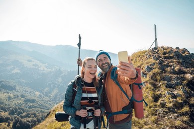 couple taking selfie while camping in the mountains