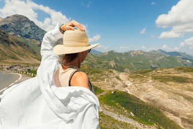young adult woman explore scenic alpine stunning mountain peak landscape view sunny day. female happy girl person enjoy alps high road pass panorama.  travel adventure tourism trip tour vacation.