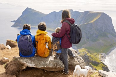 family with kids and dog, hiking in vaeroya island, the most famous hike haen, children enjoying hiking on sunny day