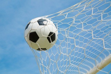 soccer ball in the goal after shooted in the game