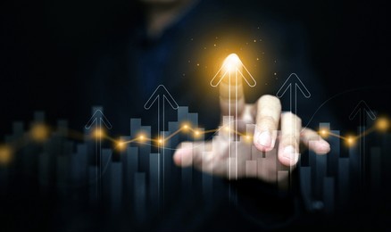 finance, business, investment, or economy growing graph concept. a man tapping on top of an arrow, analyzed data, as it rising up high. the chart and arrows represening the growth and increase.