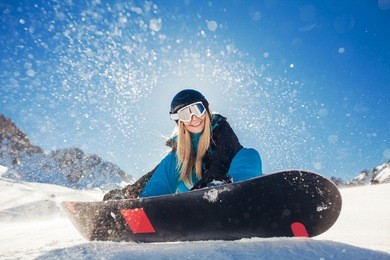 girl snowboarding in the mountains on the snowboard