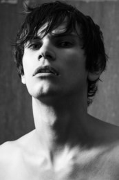 portrait of handsome man with wet hair on gray wall background. black and white portrait.