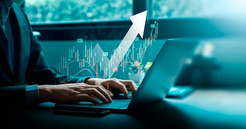 businessman analyzing stock market trends on laptop and tablet with upward arrow and trading data, representing financial growth and investment strategies in modern technology, forex trading