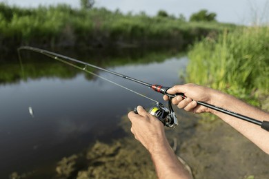 fishing in river. a fisherman with a fishing rod on the river bank. man fisherman catches a fish. fishing, spinning reel, fish, breg rivers. - the concept of a rural getaway. article about fishing.