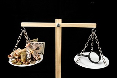 money and loupe on a two plan balance search concept