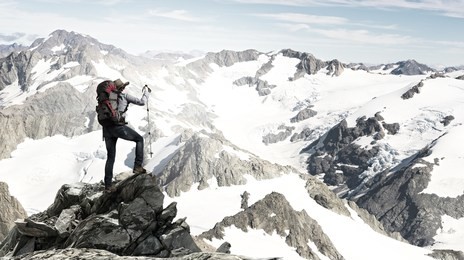 mountaineer at peak of mountain enjoying natural landscape