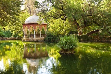 romantic pavilion reflected in a pond. parque maria luisa of sevilla, spain 