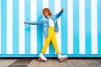 beautiful red haired young woman with rollerskates having fun outdoors - pretty female teenager girl with unique style riding on roller skates in the city