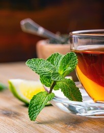 tea in a glass cup, mint leaves, dried tea, sliced lime, cane brown sugar