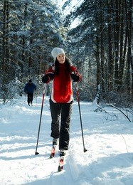 young strong woman is skiing in the forest